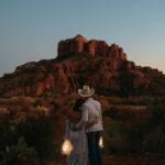 Elopement couple watching Cathedral Rock after sunset in Sedona, Arizona with lanterns.